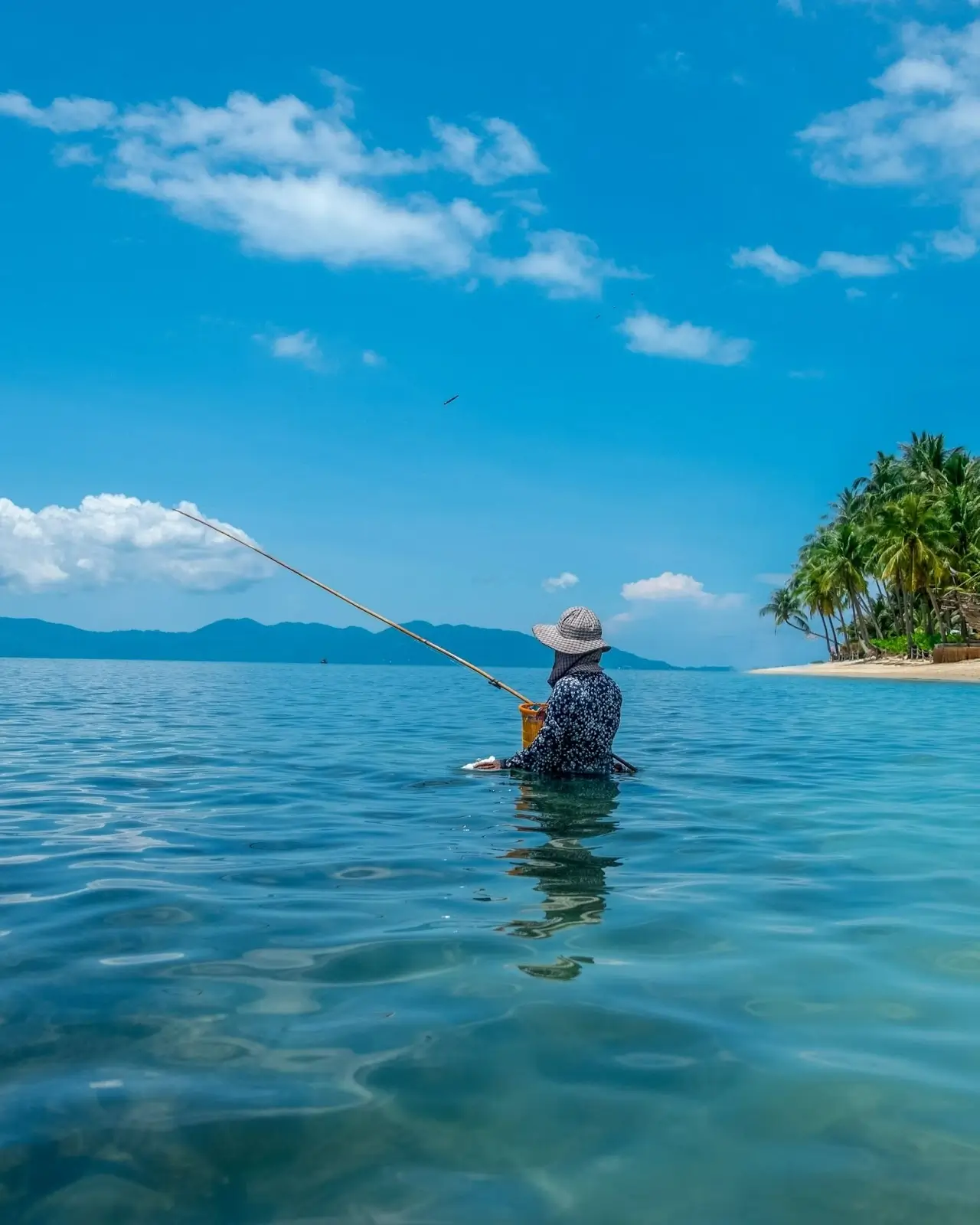 Person fishing in the ocean by Bo Phut