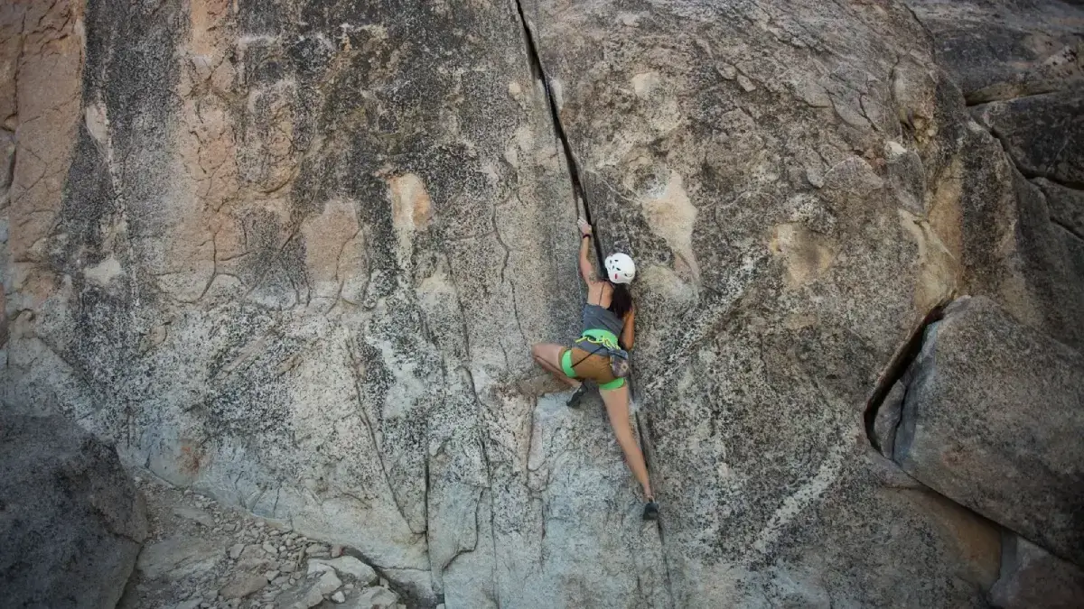 Girl climbing up a rock wall
