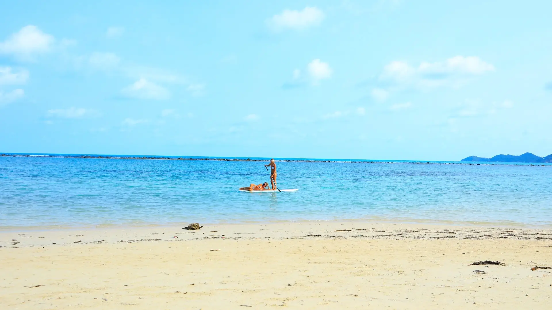 Women on paddle board (view from the beach)